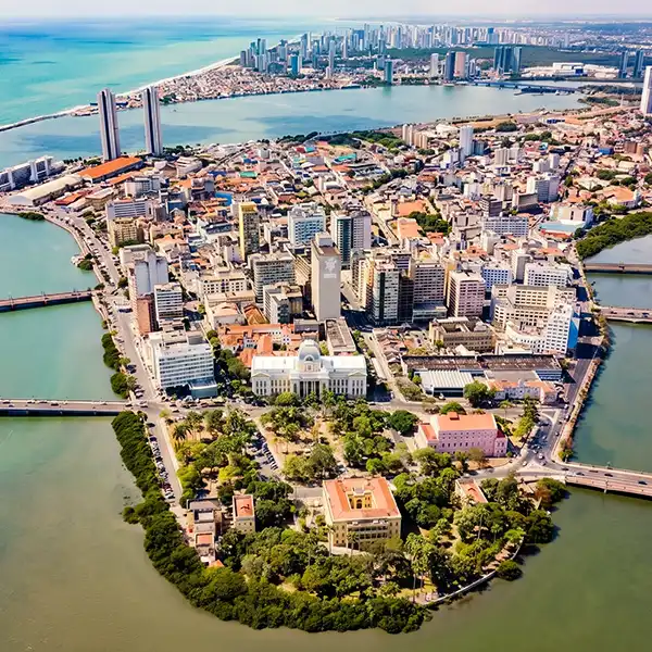Vista aérea do centro de San Antonio em Texas, com seus arranha-céus, rio, parques e áreas urbanas, mostrando a combinação de natureza e urbanismo.